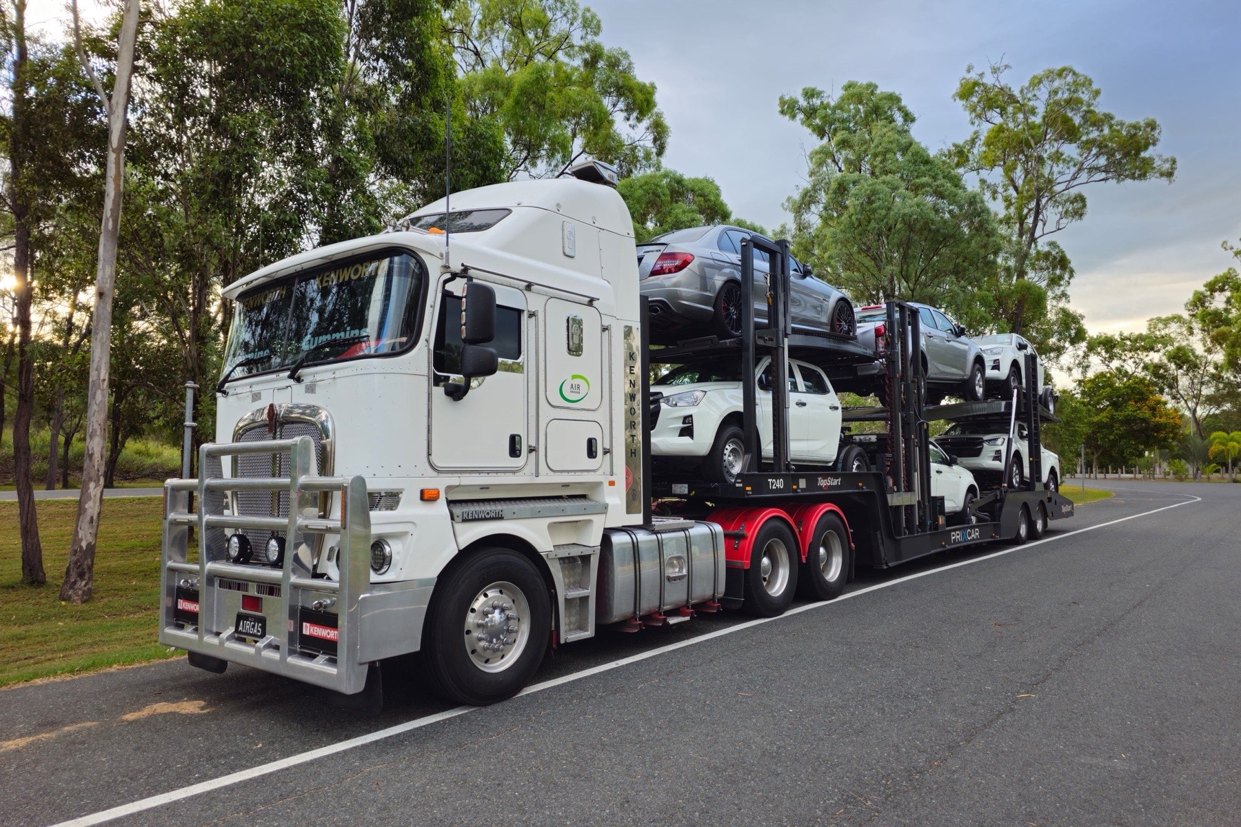 Car transporter carrying vehicles on a road, representing automotive value-chain emissions