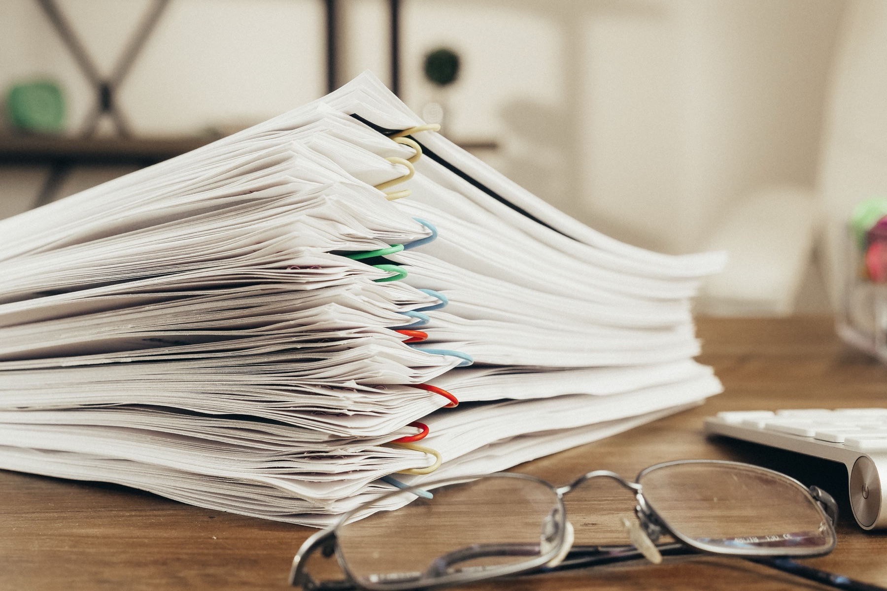 Stack of reporting documents on a desk, representing ESG reporting workload and cost
