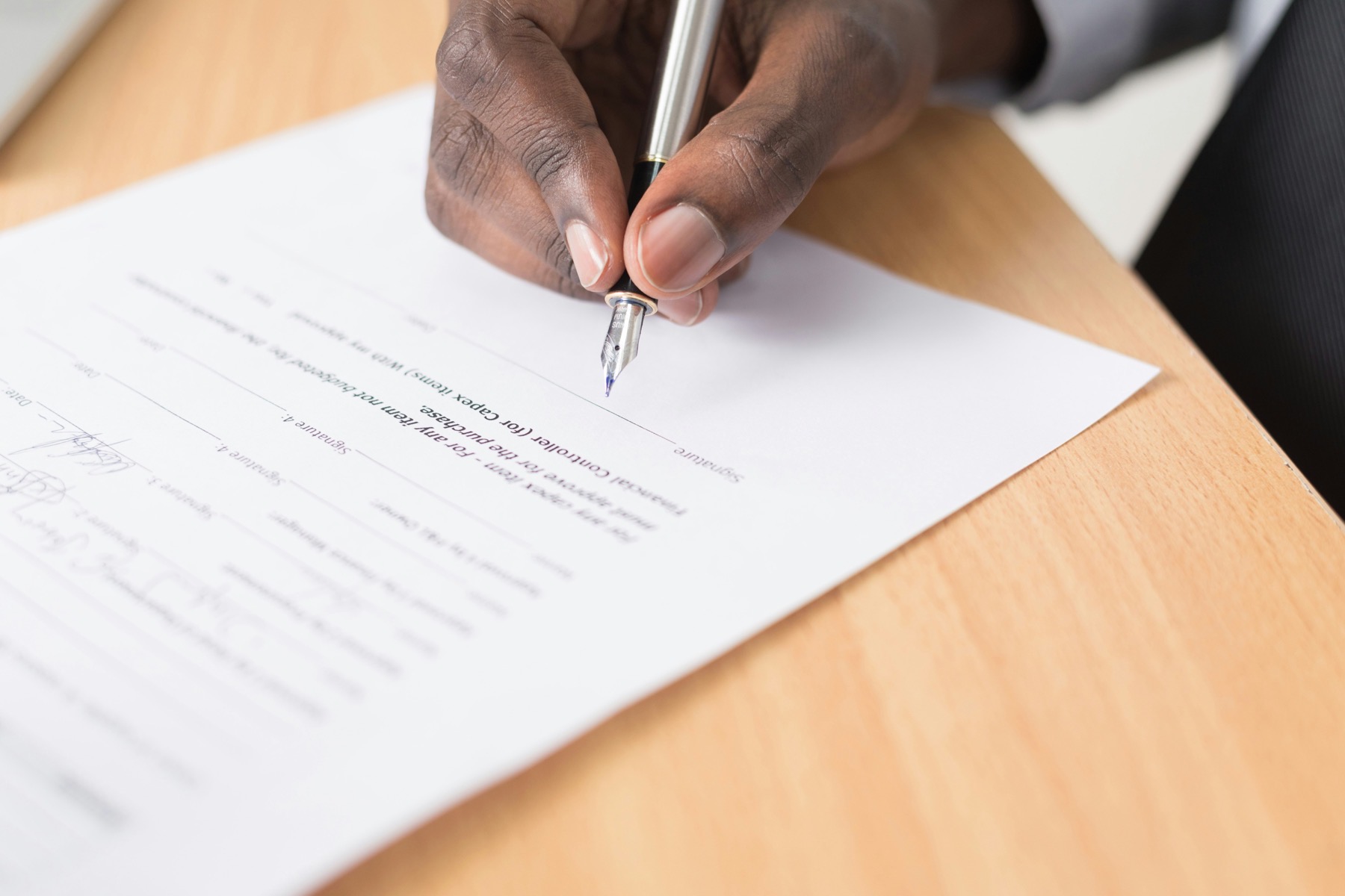 Professional signing a document representing PRI signatory commitments